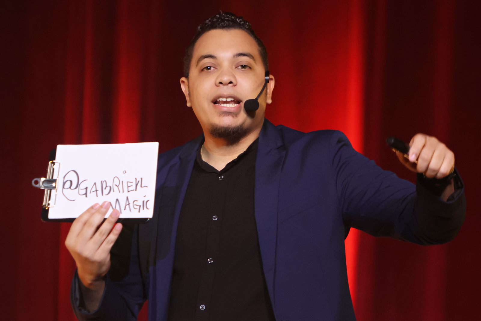 Gabriell Magic con micrófono mostrando una hoja con su usuario 